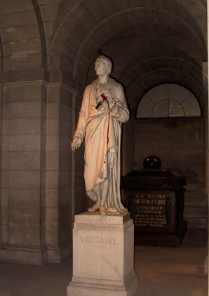 Statue of Voltaire holding a book with a bloody knife stabbed into it.
